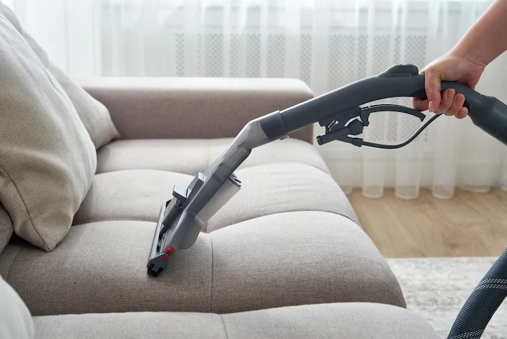 young-housewife-cleaning-sofa-with-vacuum-cleaner-living-room_130111-3639